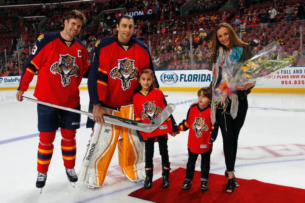 Roberto Luongo posing with his family and teammate after he was presented with a sweet stick to commemorate his 400th career win