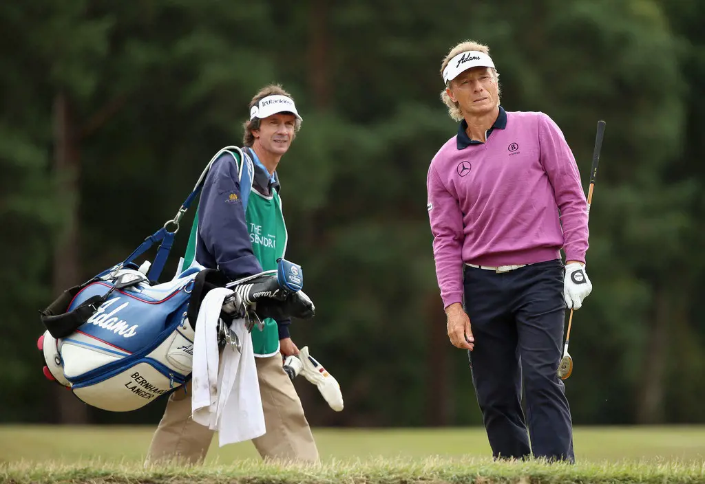 Bernhard Langer of Germany stands with his caddie Terry Holt on the second hole during the first round of The Senior Open Championship at Sunningdale Golf Club on July 23, 2015 in Sunningdale, England.