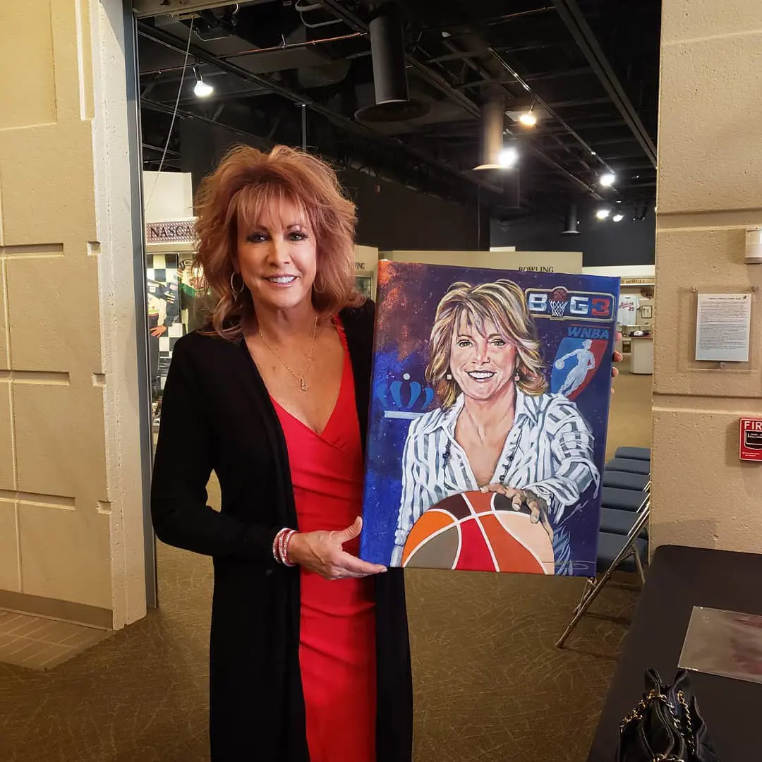 Nancy showing off hand made picture byTexas Sports Hall of Fame.