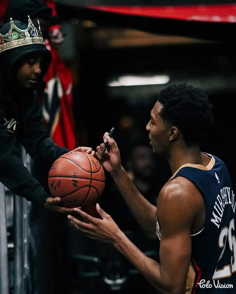 Trey Murphy III giving an autograph to a young fan in November 2022