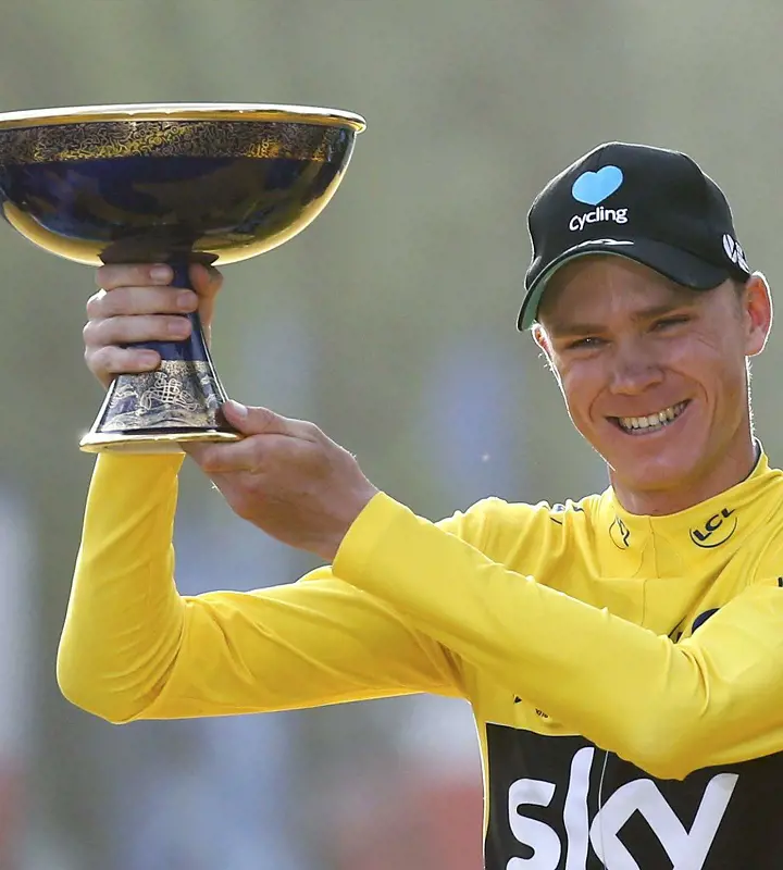 Chris Froome holds his 2017 Tour de France trophy after his 4th triumph.