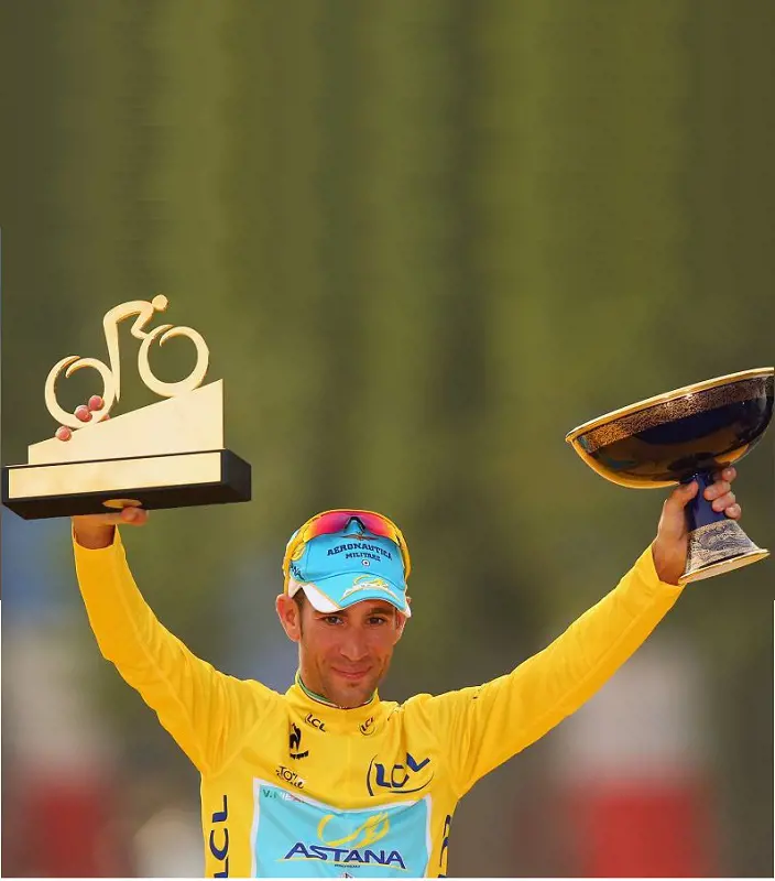 Vincenzo Nibali lifts his Mountain Class trophy (left) and Tour de France trophy (right) after 2014 victory.