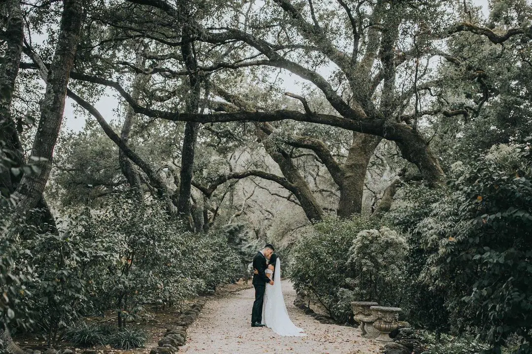 Lin with his bride posing for wedding photos in the woods. 