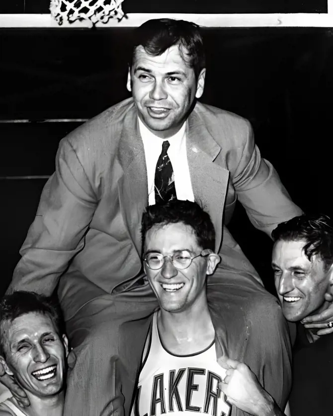 Minneapolis Lakers players lifting head coach John Kundla after their NBA championship win