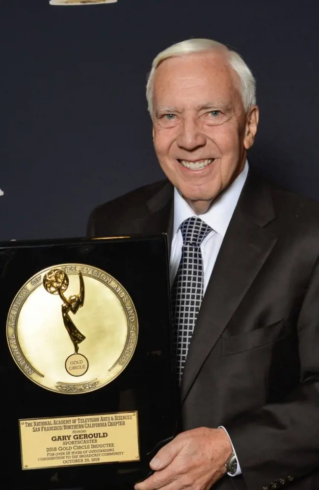 Gerould holding the 2018 Gold Circle Inductee award .