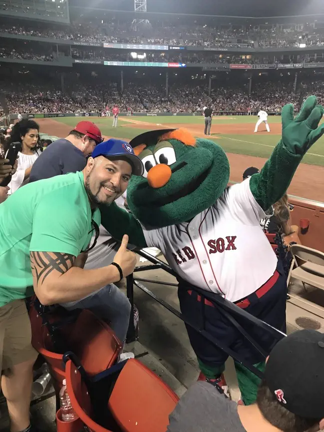 Wally the Green Monster poses with a fan for a picture