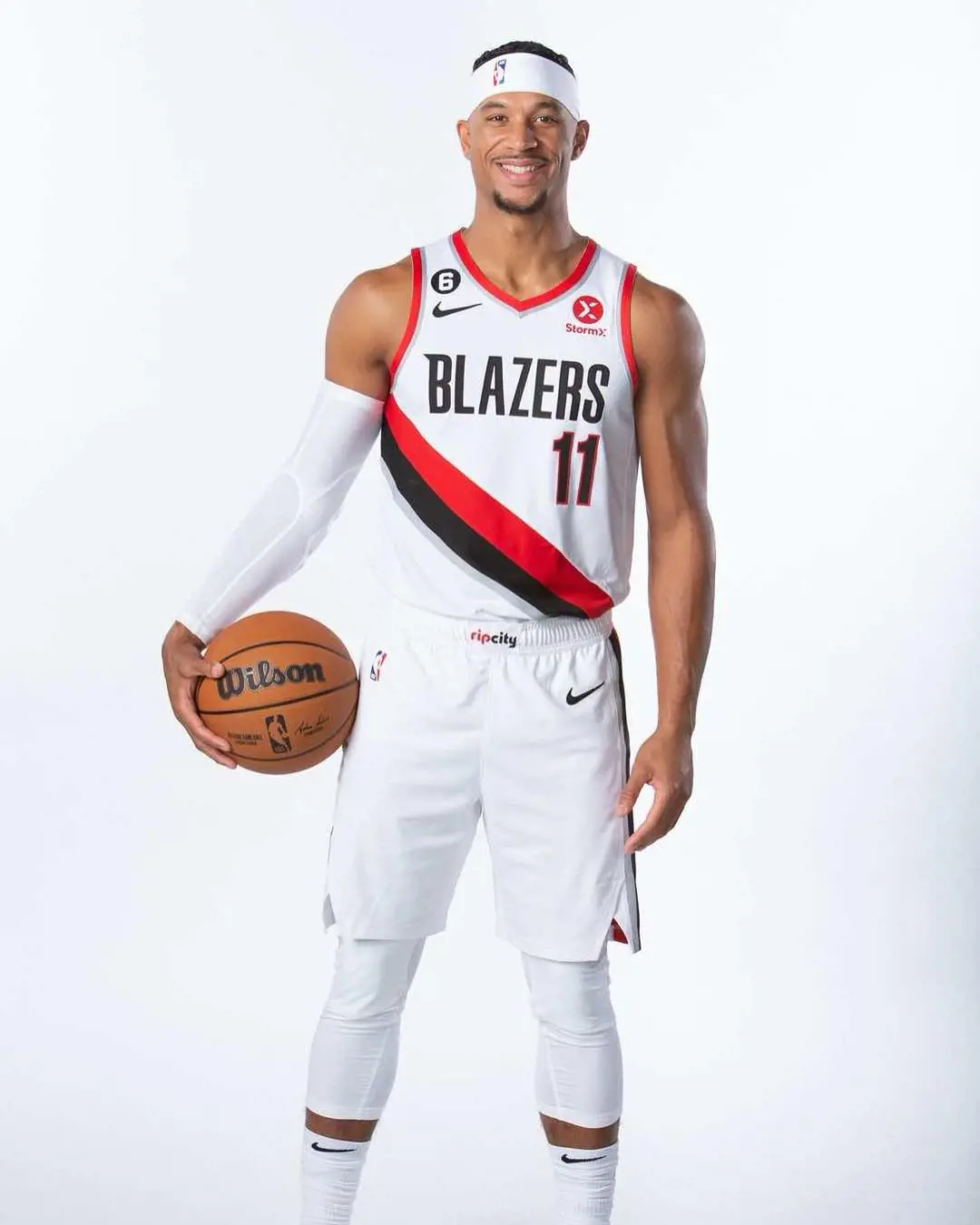 Josh posing for the picture wearing Blazers jersey and Wilson basketball on hand. 