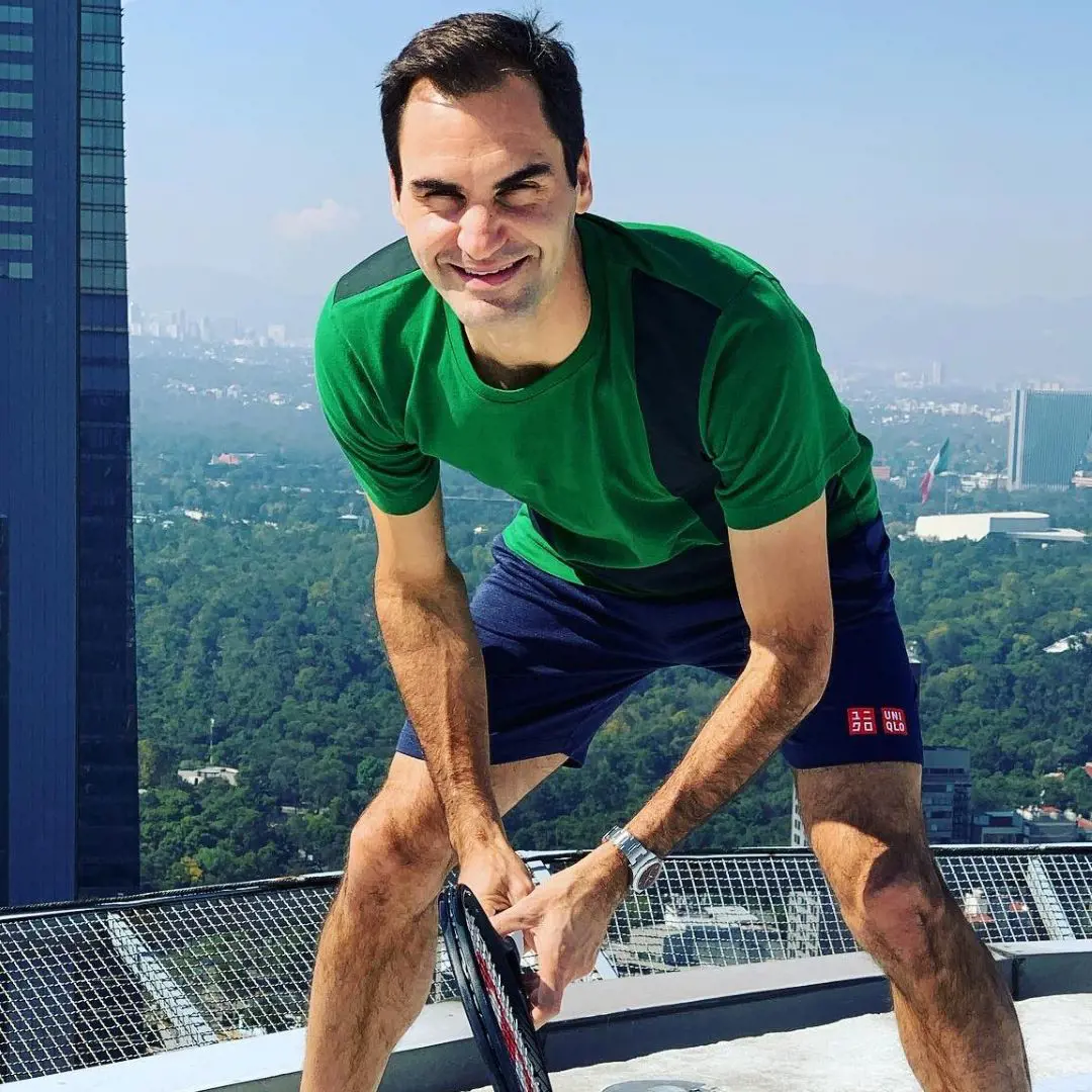 Roger Federer enacting playing tennis at a skyscraper with the audience.