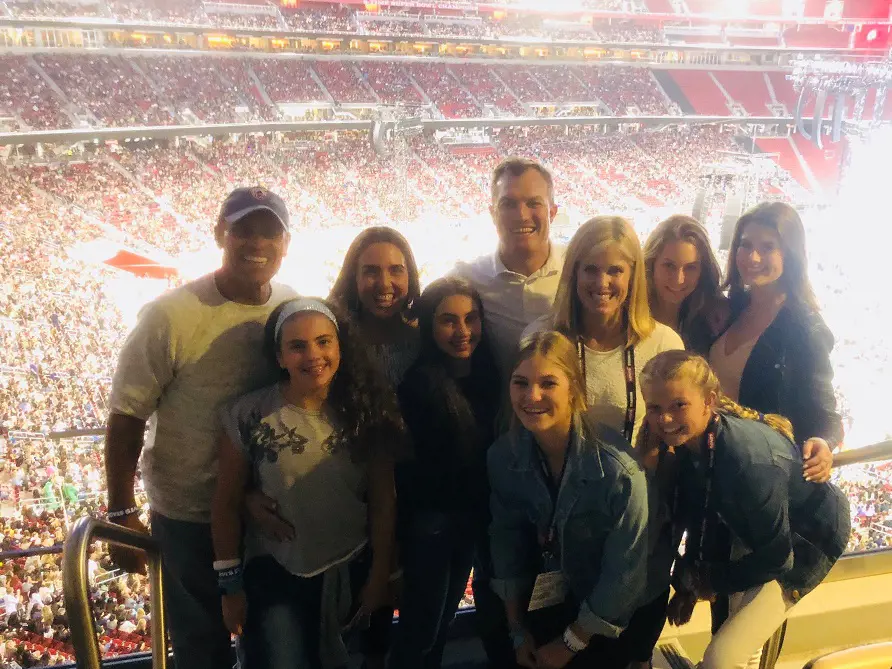 John and Linda with his fam attending a game in May 2018 along with his friend Herm Edwards (left)