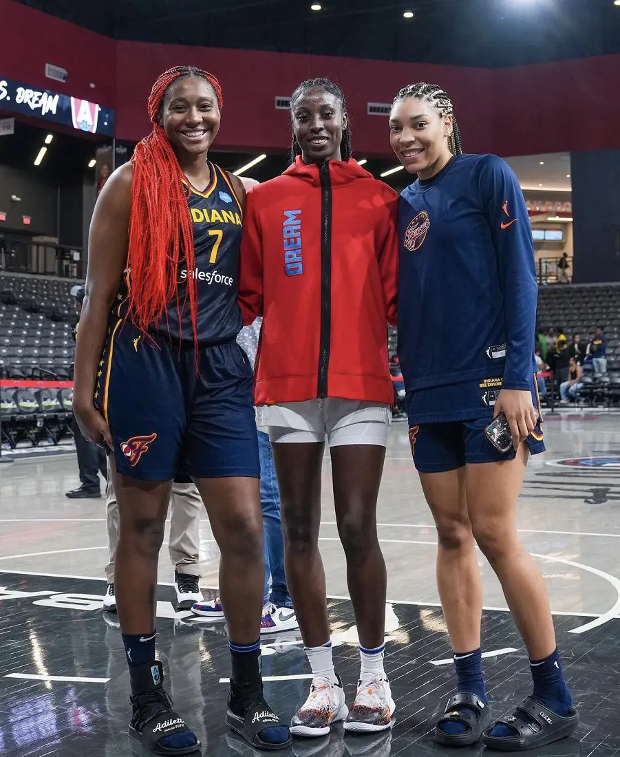 Laeticia Amihere (M) takes picture with the Indiana Fever players before the game in May 2023