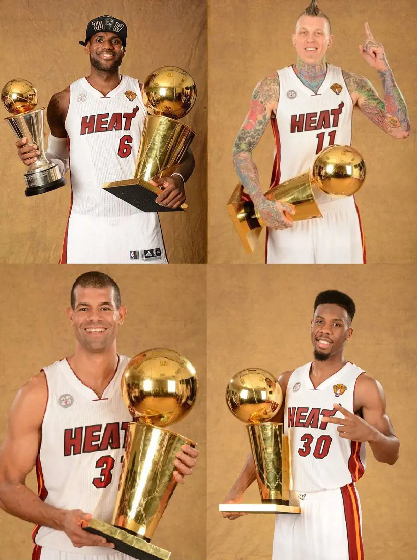 Miami Heat players pose for a photo with the NBA trophy.