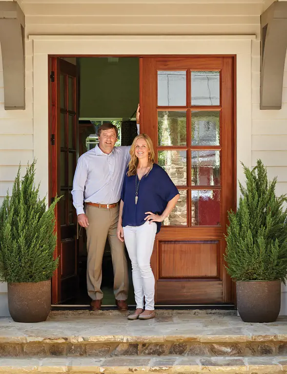 Kirby and Mary standing infront of their home in Athens.