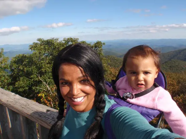 Rost carrying her daughter, Stella on her back while hiking in Pisgah tower