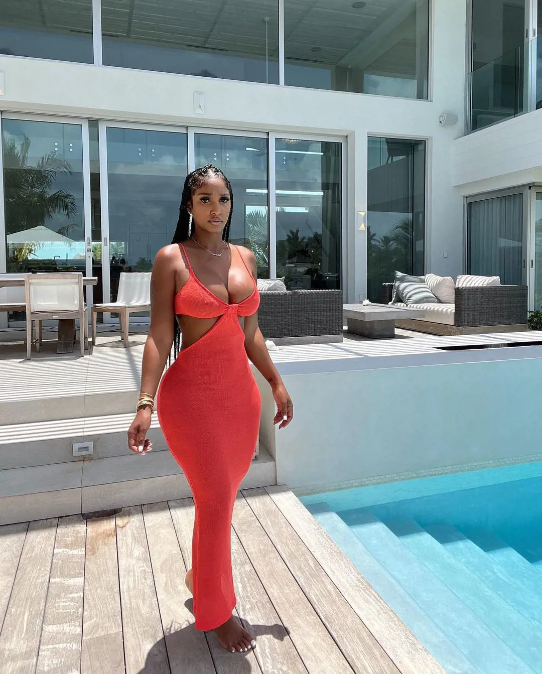 Bernice in her orange outfit near a swimming pool at Turks And Caicos 