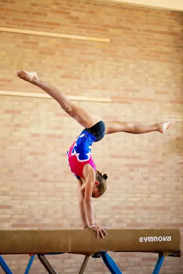 A young gymnast practicing her skills for the beam routine