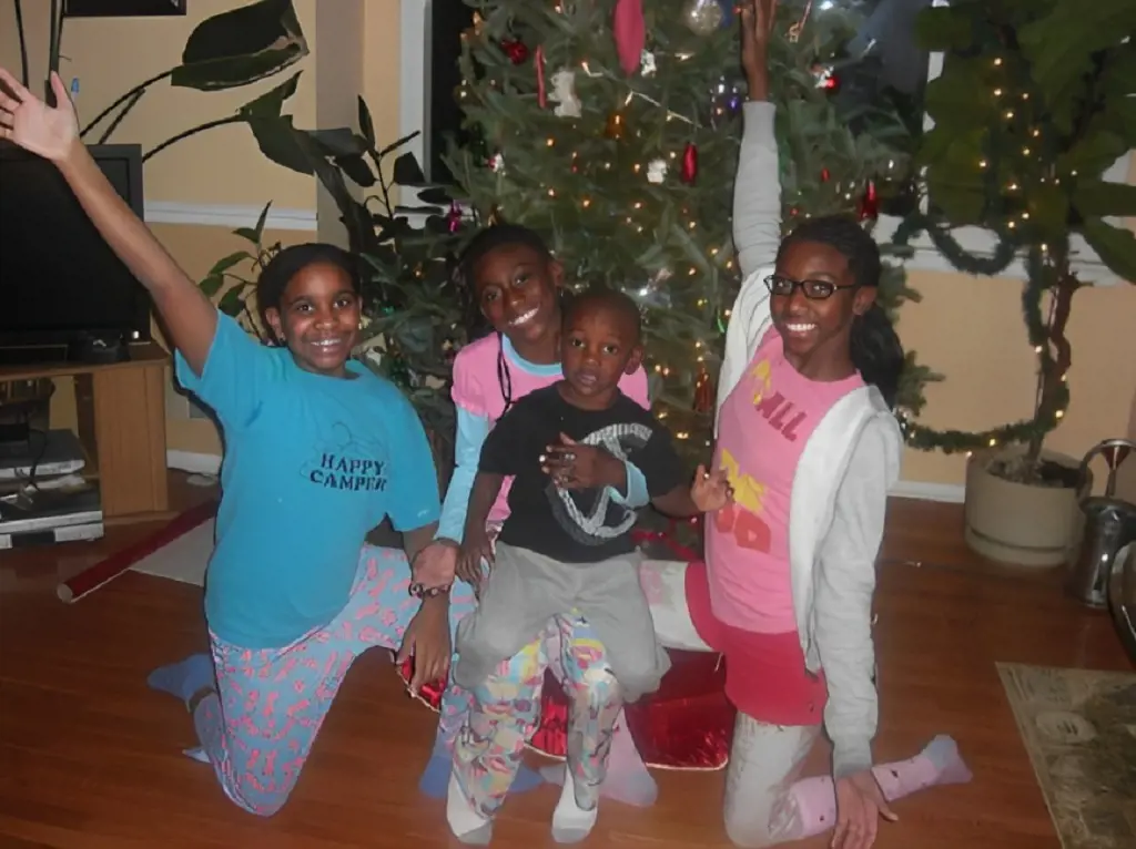 Diamond holding Landen in middle and side by side with Andreana and Laniya celebrating Christmas in 2009. 