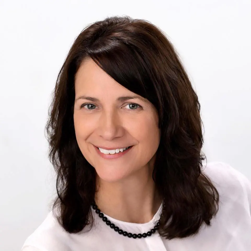 Anne's headshot portrait from March 6, 2021 donning a gorgeous white dress and black pearl jewel