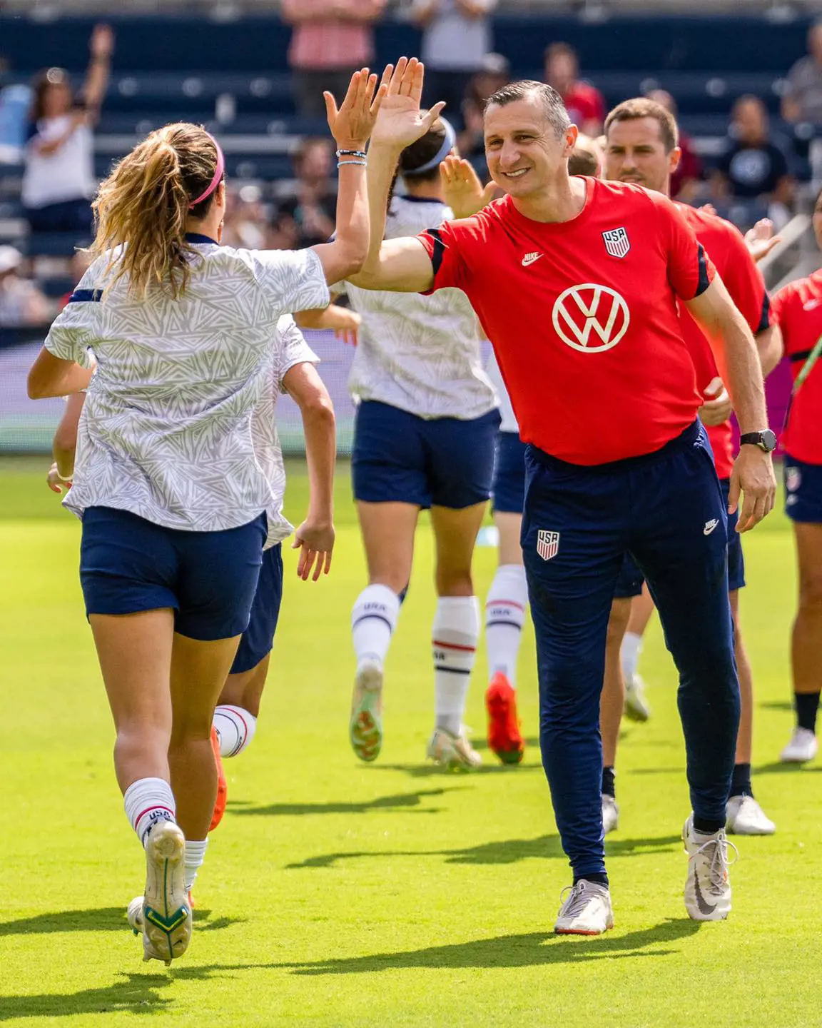 Vlatko Andonovski high fives a US international player during a warm ups in September 2022