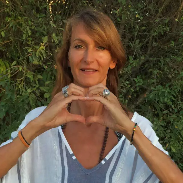 Elodie forming a heart shape with her hand while wearing bohemian rings